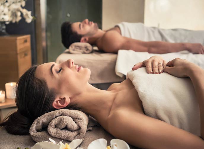 A young couple wrapped in spa towels relaxing in a massage centre with a beautiful and relaxing ambiance