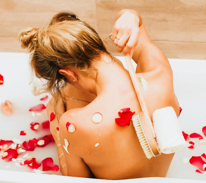 A lady in a luxury spa in a private jacuzzi with milk bath and roses getting a cleopatra treatment